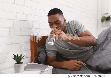 Black Man Taking Glass Of Water In Bed In Morning Black Man Taking Glass Of Water In Bed In Morning 76787935