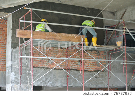SEPANG, MALAYSIA -OCTOBER 15, 2016: Construction workers plastering wall and beam using cement plaster at the construction site in Sepang, Malaysia 76787983
