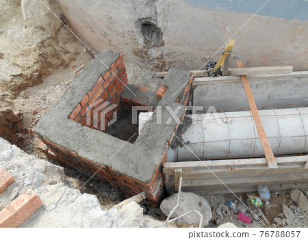 SEREMBAN, MALAYSIA -SEPTEMBER 28, 2016: Construction workers install underground precast concrete culvert at the construction site. SEREMBAN, MALAYSIA -SEPTEMBER 28, 2016: Construction workers install underground precast concrete culvert at the construction site. 76788057