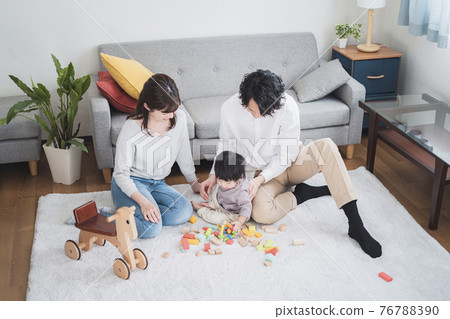 Parents in their 30s playing in the living room with a 1 year old boy 76788390
