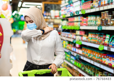 Sick Muslim Lady Coughing In Elbow Buying Food In Supermarket Sick Muslim Lady Coughing In Elbow Buying Food In Supermarket 76788483