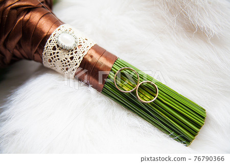 bridal bouquet and rings on white background 76790366