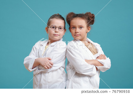 Two little girls in white coats 76790938