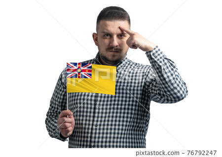 White guy holding a flag of Niue and a finger touches the temple on the head isolated on a white background White guy holding a flag of Niue and a finger touches the temple on the head isolated on a white background 76792247