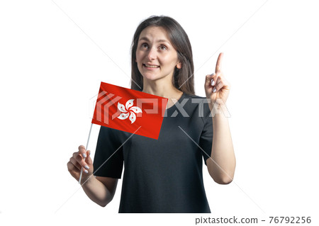 Happy young white woman holding flag of Hong Kong and points thumbs up isolated on a white background Happy young white woman holding flag of Hong Kong and points thumbs up isolated on a white background 76792256