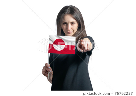 Happy young white woman holding flag of Greenland and points forward in front of him isolated on a white background Happy young white woman holding flag of Greenland and points forward in front of him isolated on a white background 76792257