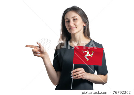 Happy young white woman holding flag Isle of Man and points to the left isolated on a white background 76792262