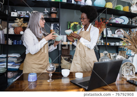 Two diverse female workers doing inventory at decor shop 76792908