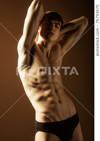 Muscle strong beautiful stripped male model in black jeans on black isolated font background Muscle strong beautiful stripped male model in black jeans on black isolated font background 76793670