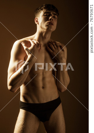 Muscle strong beautiful stripped male model in black jeans on black isolated font background Muscle strong beautiful stripped male model in black jeans on black isolated font background 76793671