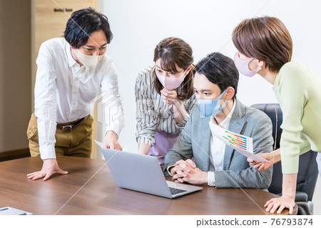 A businessman wearing a mask and having a meeting A businessman wearing a mask and having a meeting 76793874