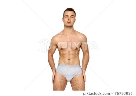 Strong stripped muscle male model in gray underwear on black isolated font background Strong stripped muscle male model in gray underwear on black isolated font background 76793955