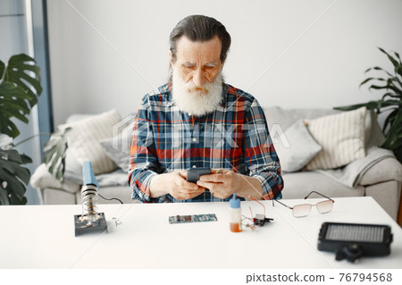 Senior technician check phone after repairment Senior technician check phone after repairment 76794568