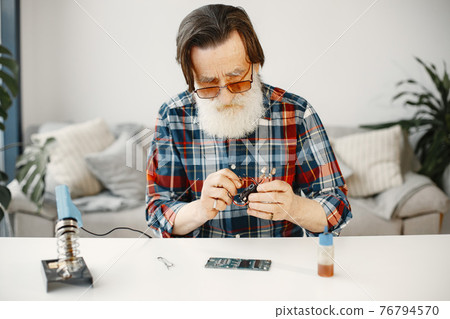 Male tech repairs electronic equipment at home Male tech repairs electronic equipment at home 76794570
