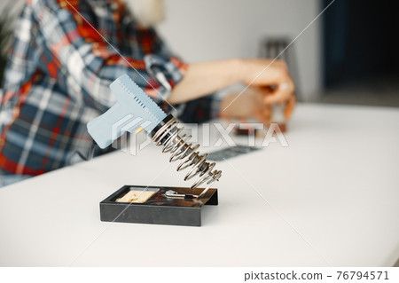 Male tech repairs electronic equipment at home 76794571