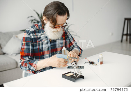 Male tech repairs electronic equipment at home Male tech repairs electronic equipment at home 76794573