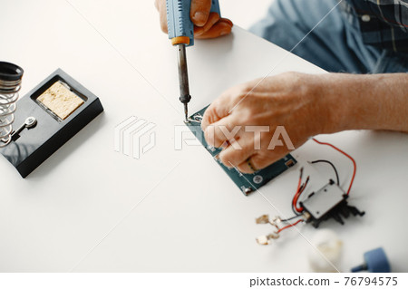 Male tech repairs electronic equipment at home Male tech repairs electronic equipment at home 76794575