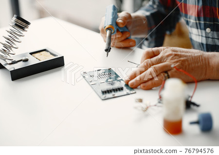 Male tech repairs electronic equipment at home Male tech repairs electronic equipment at home 76794576