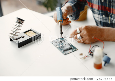 Male tech repairs electronic equipment at home Male tech repairs electronic equipment at home 76794577