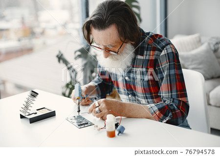 Male tech repairs electronic equipment at home Male tech repairs electronic equipment at home 76794578