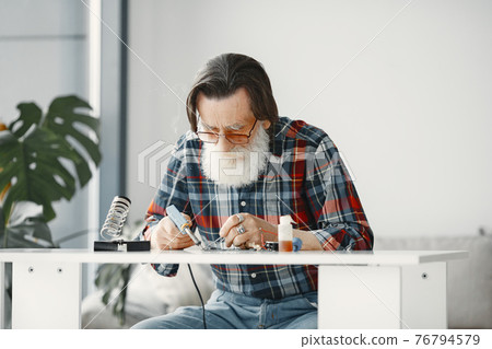 Male tech repairs electronic equipment at home Male tech repairs electronic equipment at home 76794579