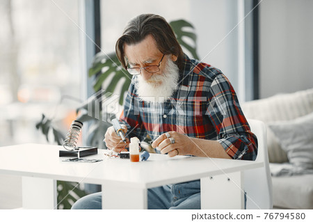 Male tech repairs electronic equipment at home Male tech repairs electronic equipment at home 76794580