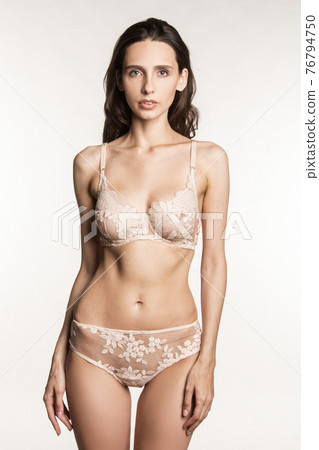 Stunning beautiful dark hair girl stripped in lingerie on white isolated font background Stunning beautiful dark hair girl stripped in lingerie on white isolated font background 76794750