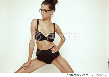 Stunning beautiful dark hair girl stripped in lingerie on white isolated font background Stunning beautiful dark hair girl stripped in lingerie on white isolated font background 76794767