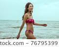 Stunning beautiful dark hair girl stripped in swimsuit on the sunset at he beach 76795399