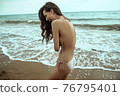 Stunning beautiful dark hair girl stripped in swimsuit on the sunset at he beach 76795401