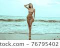 Stunning beautiful dark hair girl stripped in swimsuit on the sunset at he beach 76795402