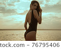 Stunning beautiful dark hair girl stripped in swimsuit on the sunset at he beach 76795406