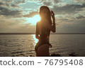 Stunning beautiful dark hair girl stripped in swimsuit on the sunset at he beach 76795408