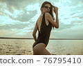 Stunning beautiful dark hair girl stripped in swimsuit on the sunset at he beach 76795410