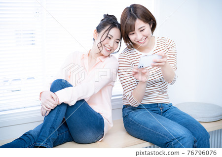 兩名女性在智能手機上觀看視頻 76796076