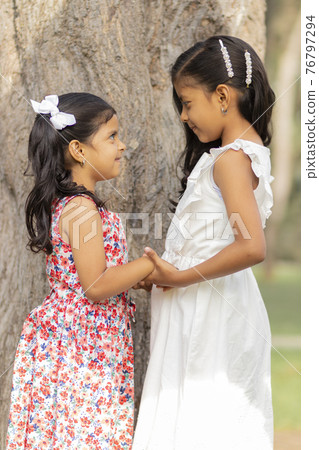 Tender little sisters hugging each other and showing their true love 76797294