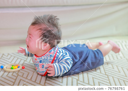 A 5-month-old boy on all fours with his limbs floating off the floor A 5-month-old boy on all fours with his limbs floating off the floor 76798761