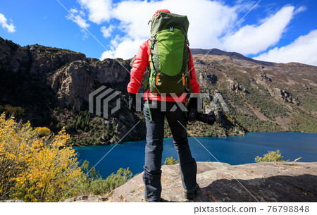 Woman photographer with camera in beautiful high altitude winter mountains Woman photographer with camera in beautiful high altitude winter mountains 76798848