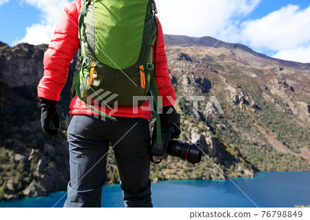 Woman photographer with camera in beautiful high altitude winter mountains Woman photographer with camera in beautiful high altitude winter mountains 76798849