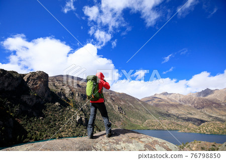 Woman photographer with camera in beautiful high altitude winter mountains 76798850