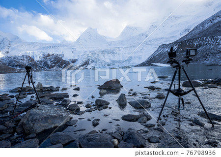 Camera on tripod taking picture of high altitude mountain landscape 76798936