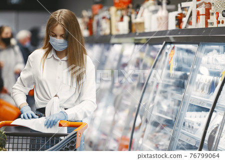 Woman in a medical mask in a supermarket 76799064