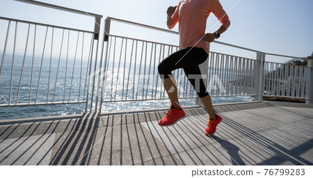Healthy lifestyle fitness sports woman runner running on seaside trail Healthy lifestyle fitness sports woman runner running on seaside trail 76799283