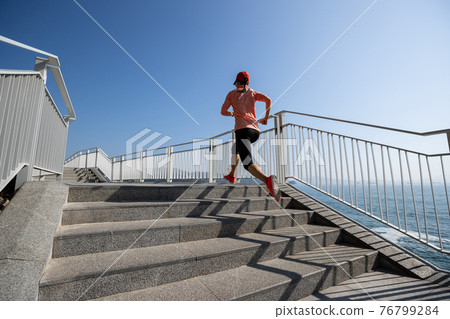 Healthy lifestyle fitness sports woman runner running up stairs on seaside trail Healthy lifestyle fitness sports woman runner running up stairs on seaside trail 76799284
