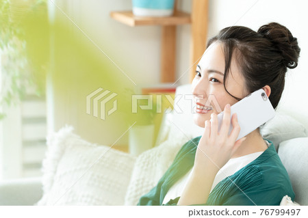 年輕女子在智能手機上交談 76799497