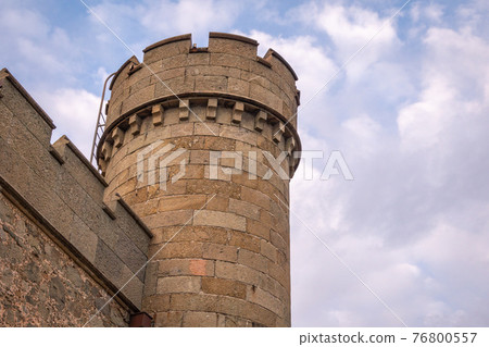 The walls and towers of the old palace on the background of a cloudy sky 76800557