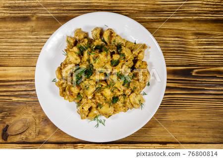 Stewed mushrooms with sour cream on wooden table. Top view Stewed mushrooms with sour cream on wooden table. Top view 76800814