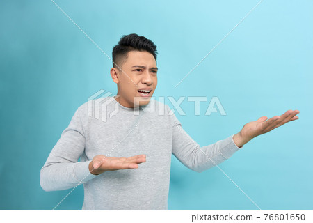 Closeup side view profile portrait of angry upset young man isolated on blue background. 76801650