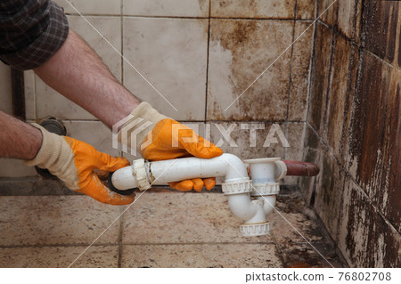 Worker fixing old pipeline in a bathroom Worker fixing old pipeline in a bathroom 76802708