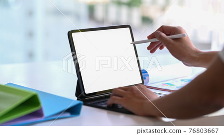 Close up view of businessman holding stylus pen pointing on screen of digital tablet. Close up view of businessman holding stylus pen pointing on screen of digital tablet. 76803667